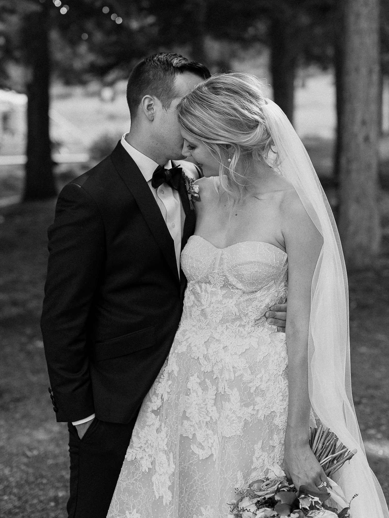 Elegant bride and groom share a romantic moment at The Ritz-Carlton Tahoe, surrounded by trees and natural beauty.