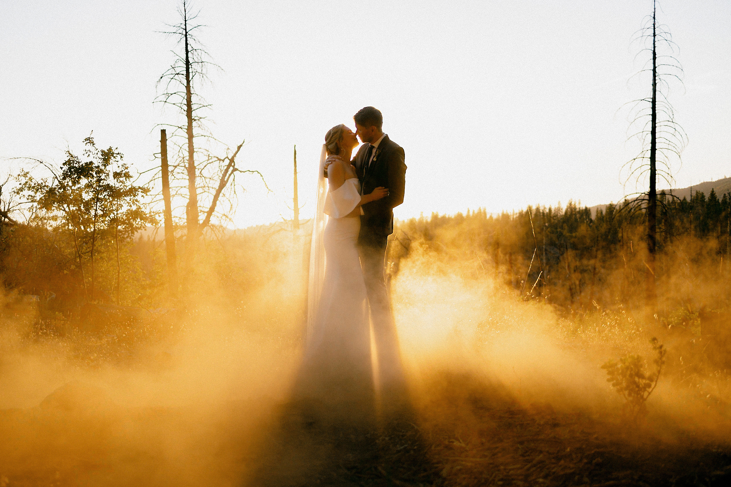 Sunset Embrace: A Couple Silhouetted in Mist at Yosemites Evergreen Lodge Forest.