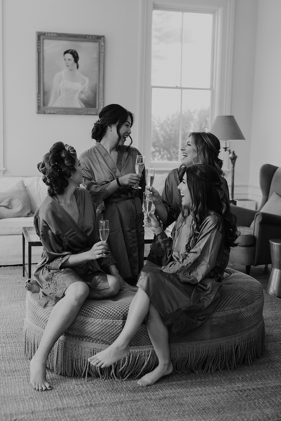 Elegant bridal party in robes at Cuffey Cove, toasting with champagne; capturing joyous moments.
