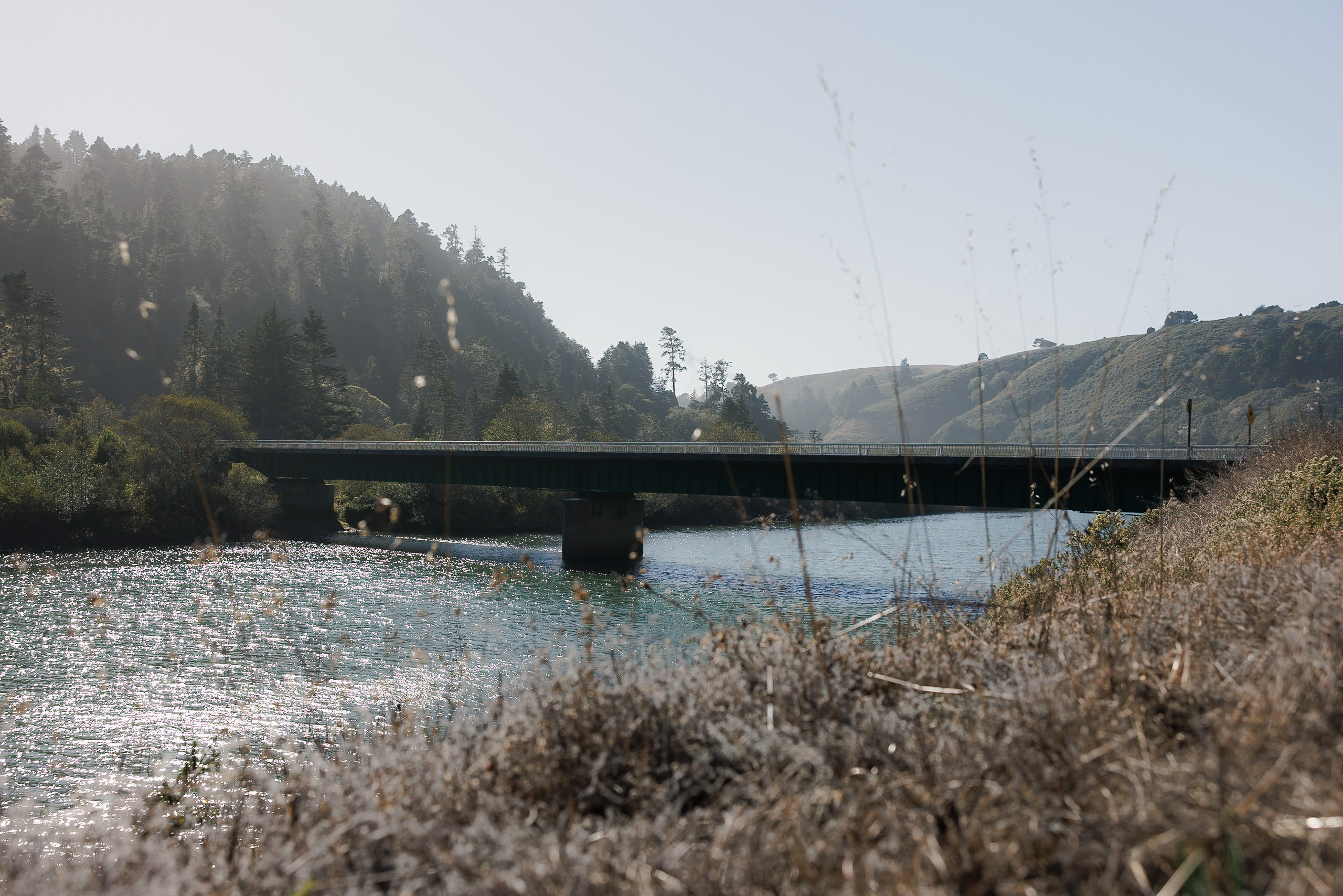 High-end Wedding Photography: Serene Mendocino Bridge Over River with Scenic Hills and Clear Skies.