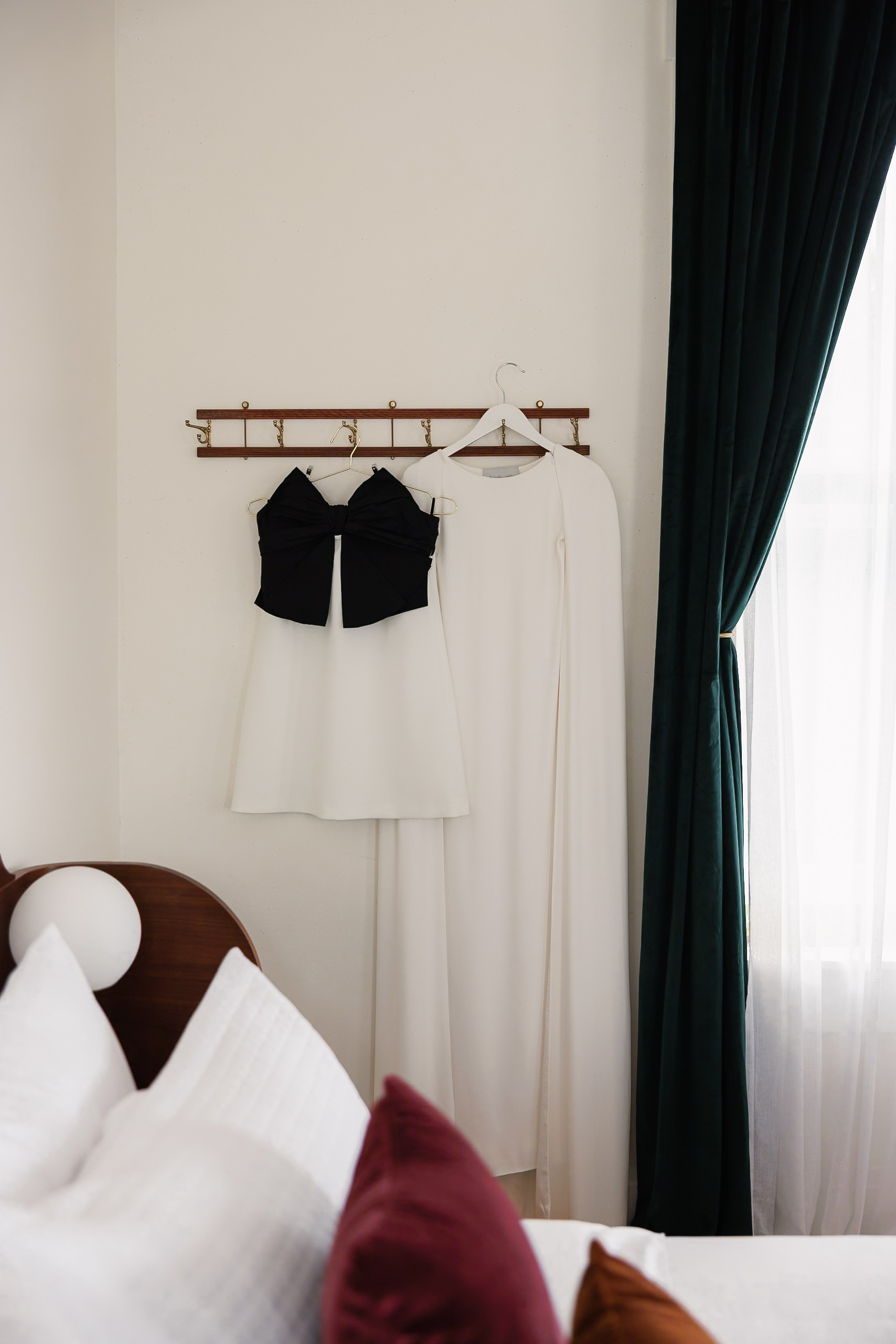 Exquisite Mendocino white wedding dress with black bow, cape & elegant window view for bridal elegance.