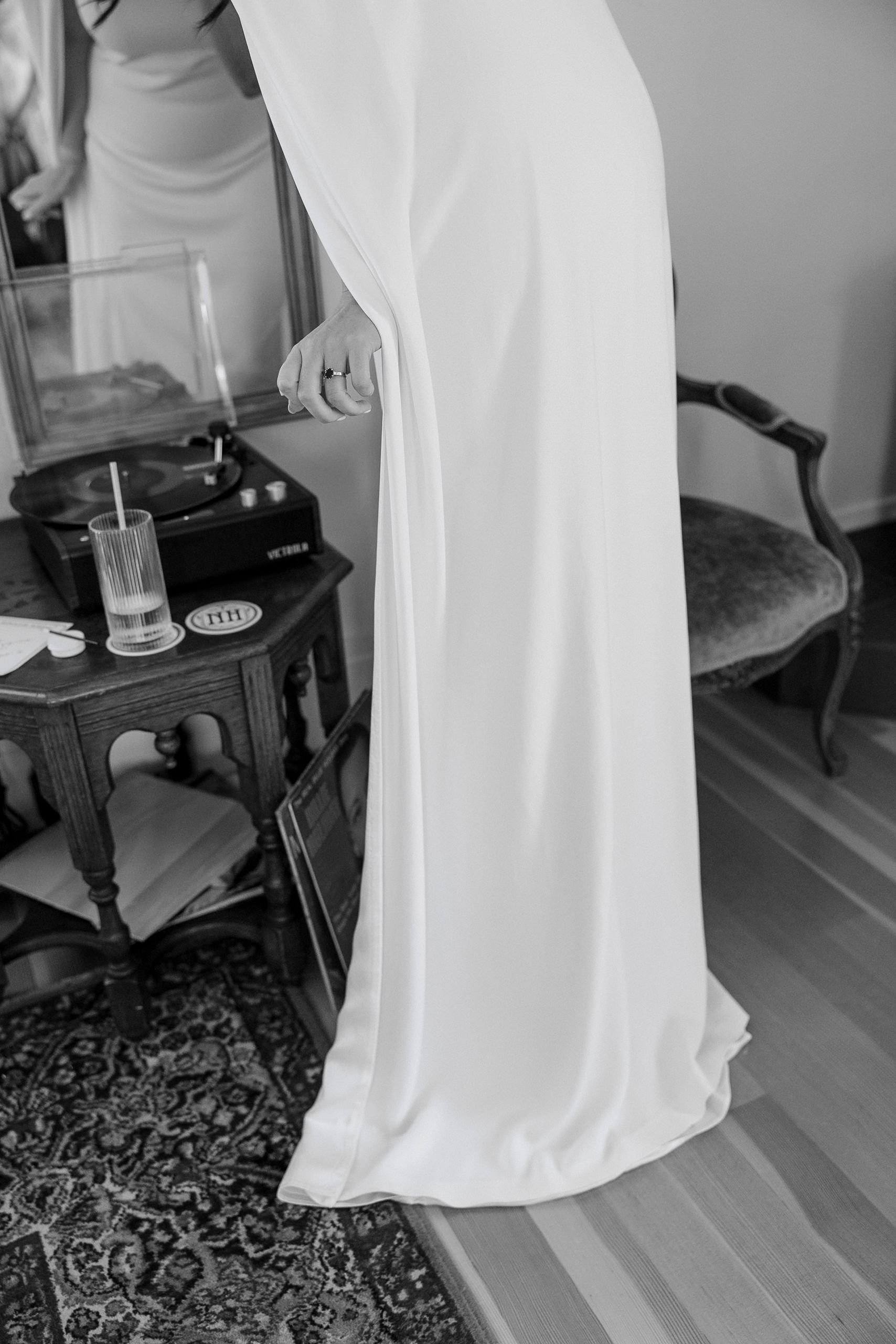 Elegant bride beside a vintage record player, Mendocino-inspired decor. Black and white photograph.