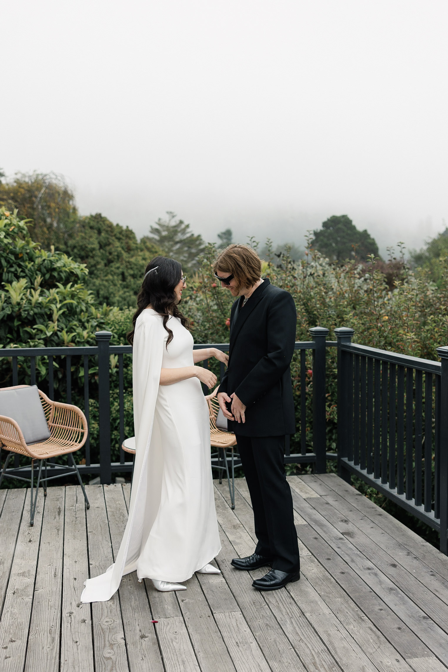 Mendocino Wedding Photographer: Couple Embraces in Fog, Bride in White Cape Dress, Groom in Black Suit.