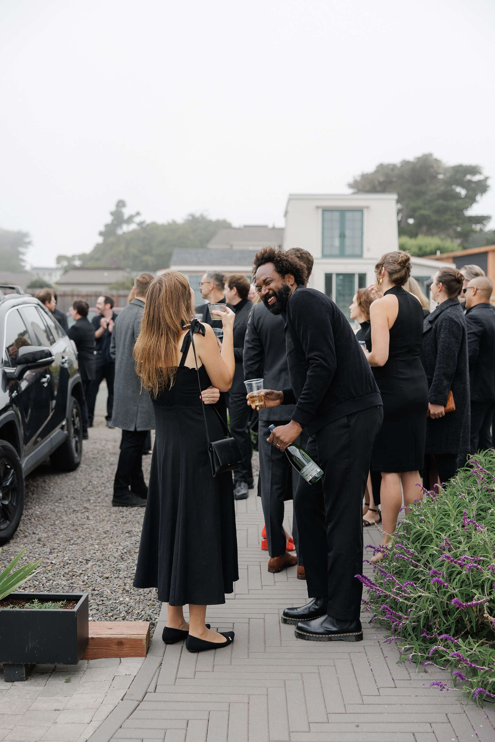 Elegant outdoor wedding gathering in Mendocino: guests in formal attire with scenic backdrop.