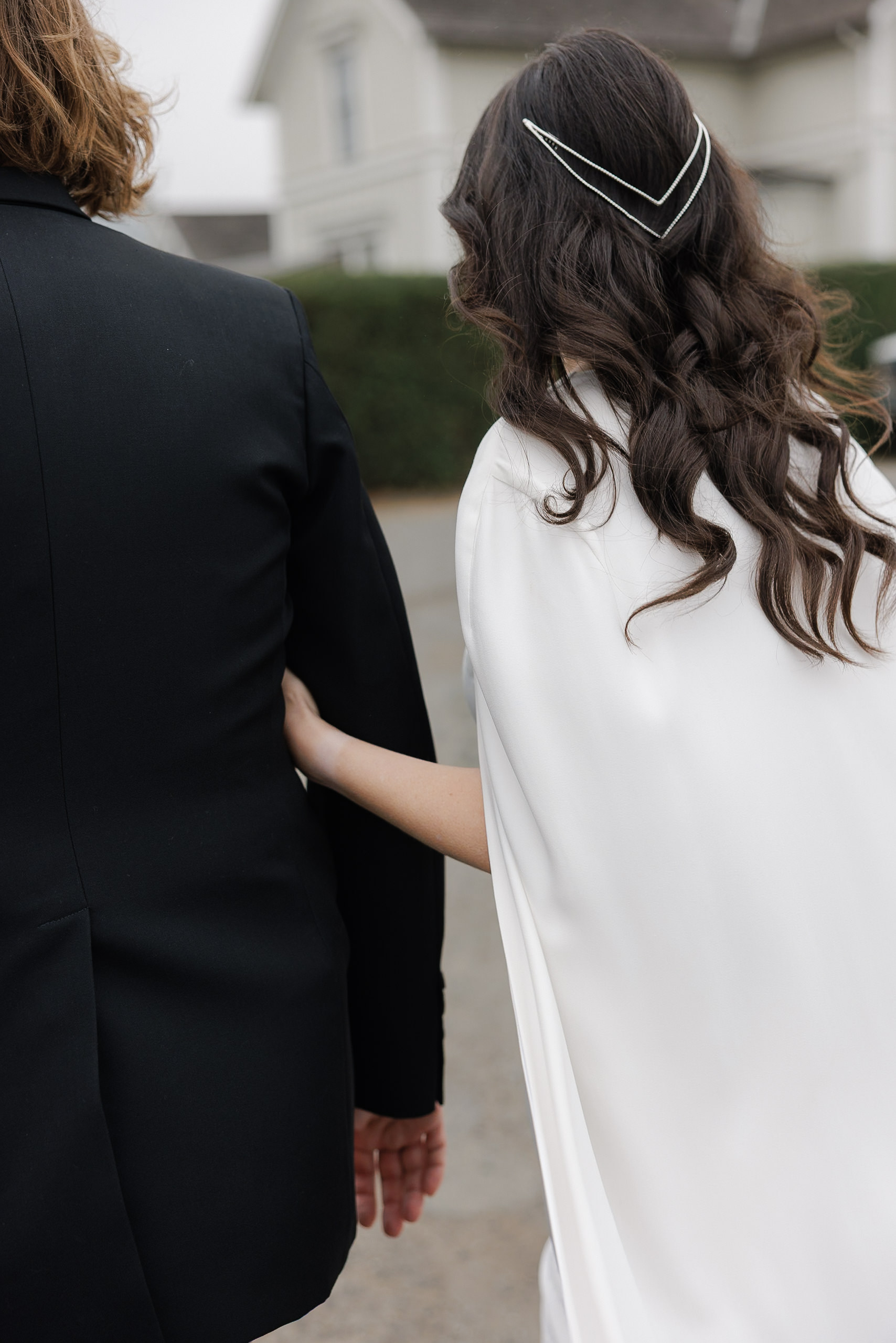Mendocino Wedding Photography: Couple Stroll Amidst Scenic Charm in Elegant Attire.