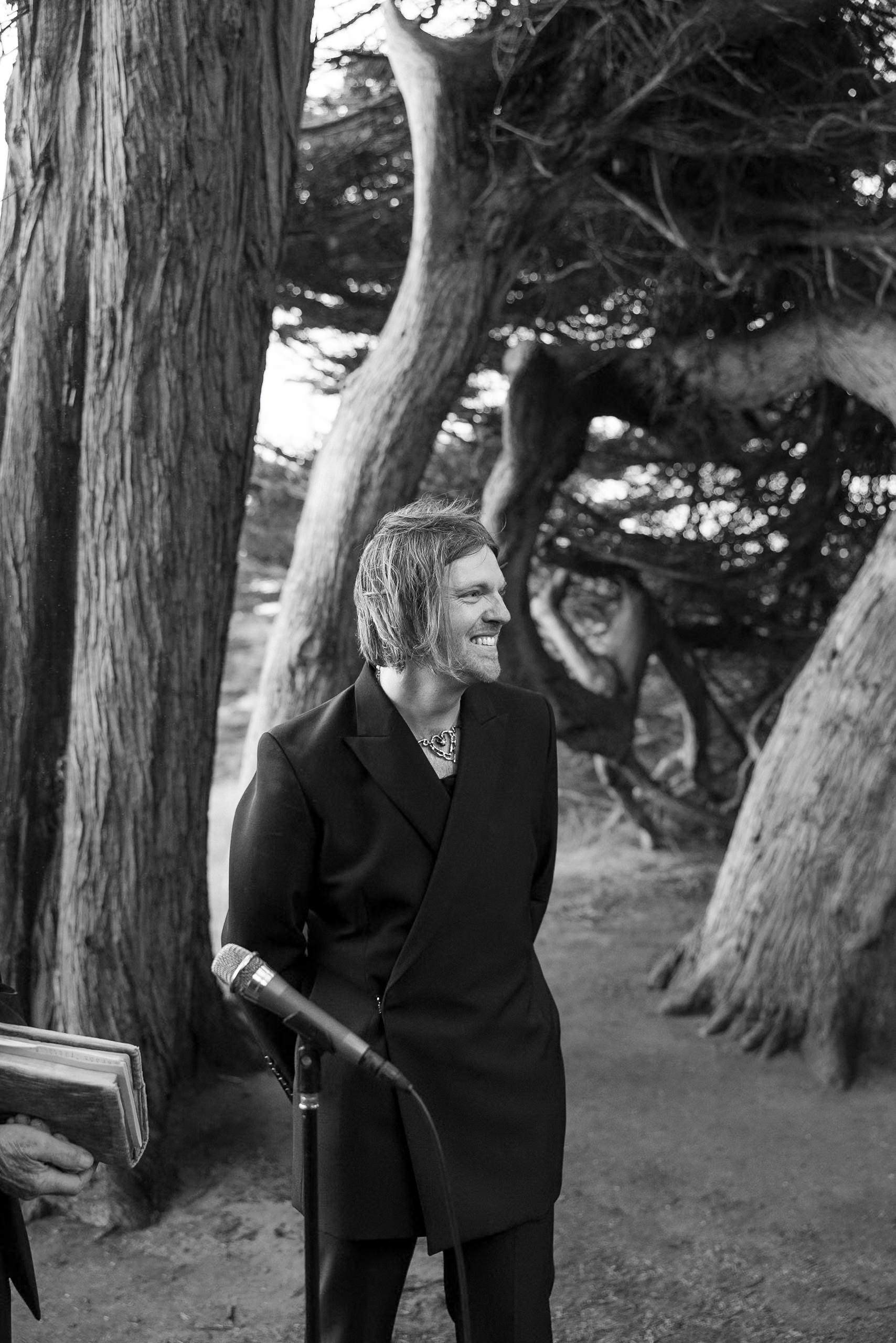 Elegant black-and-white portrait of a smiling individual with Mendocinos scenic trees, ideal for wedding photography inspiration.