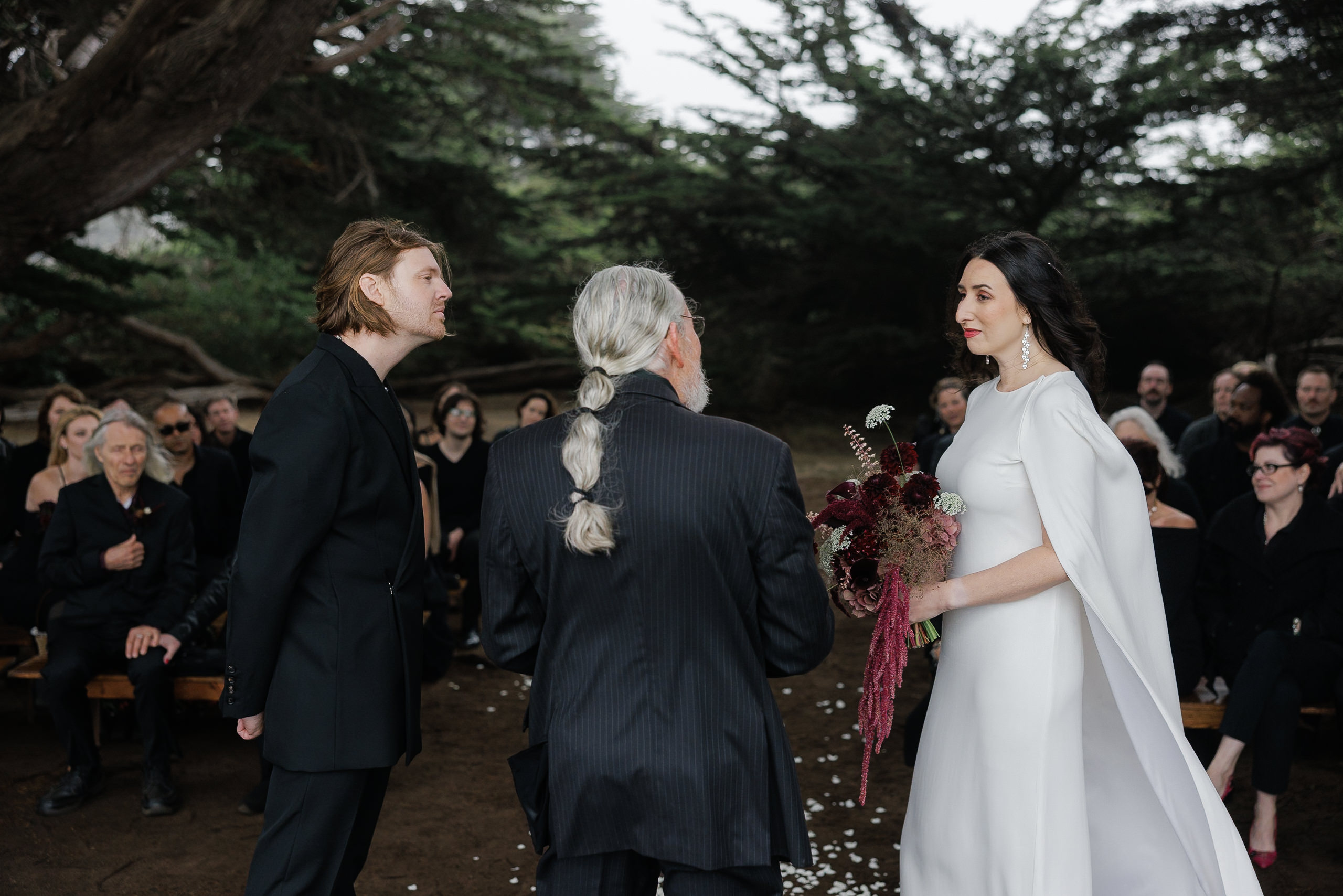High-end Mendocino wedding photographer captures couple exchanging vows with scenic outdoor backdrop.