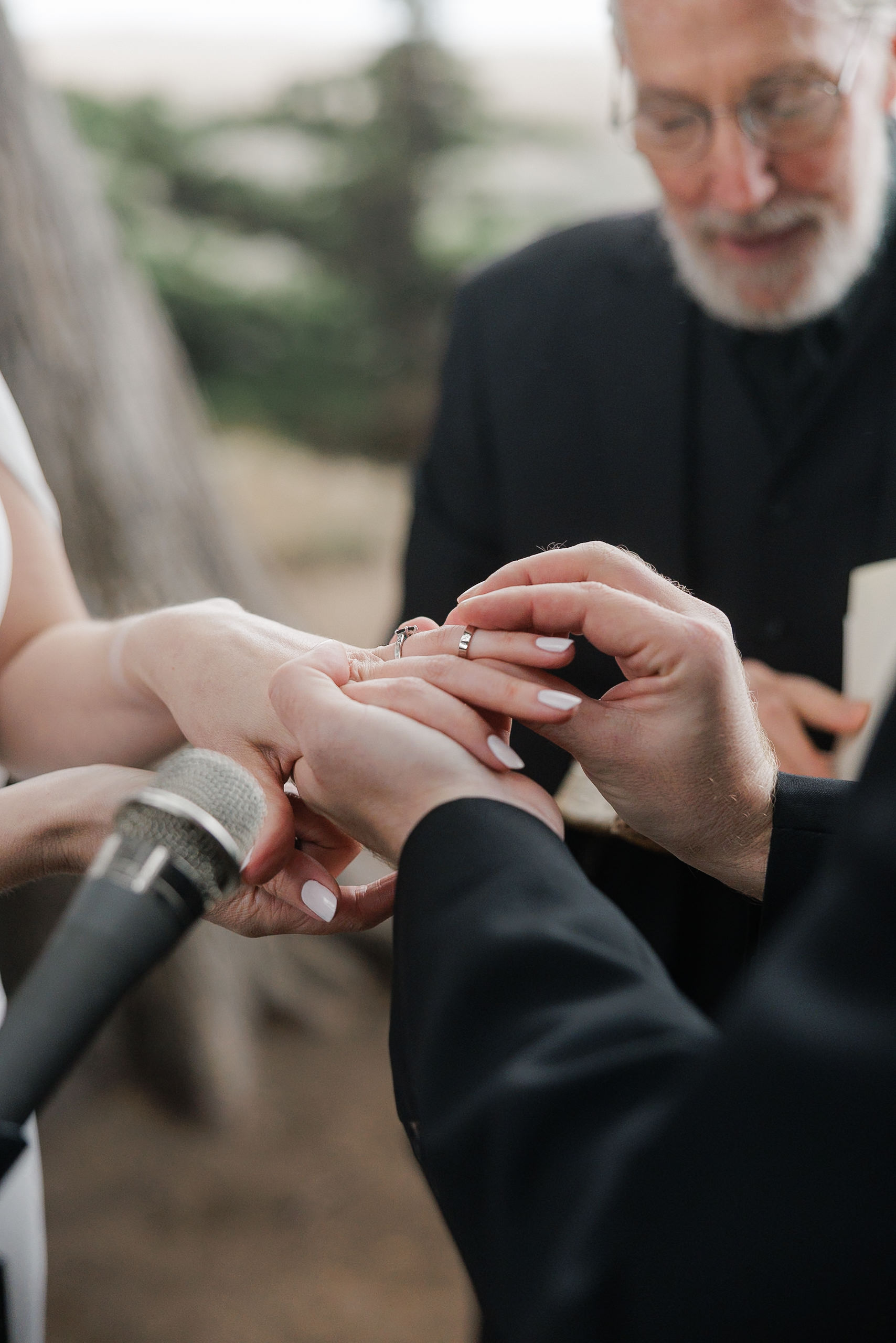 In enchanting Mendocino, a ring exchange under trees marks an elegant outdoor wedding ceremony.