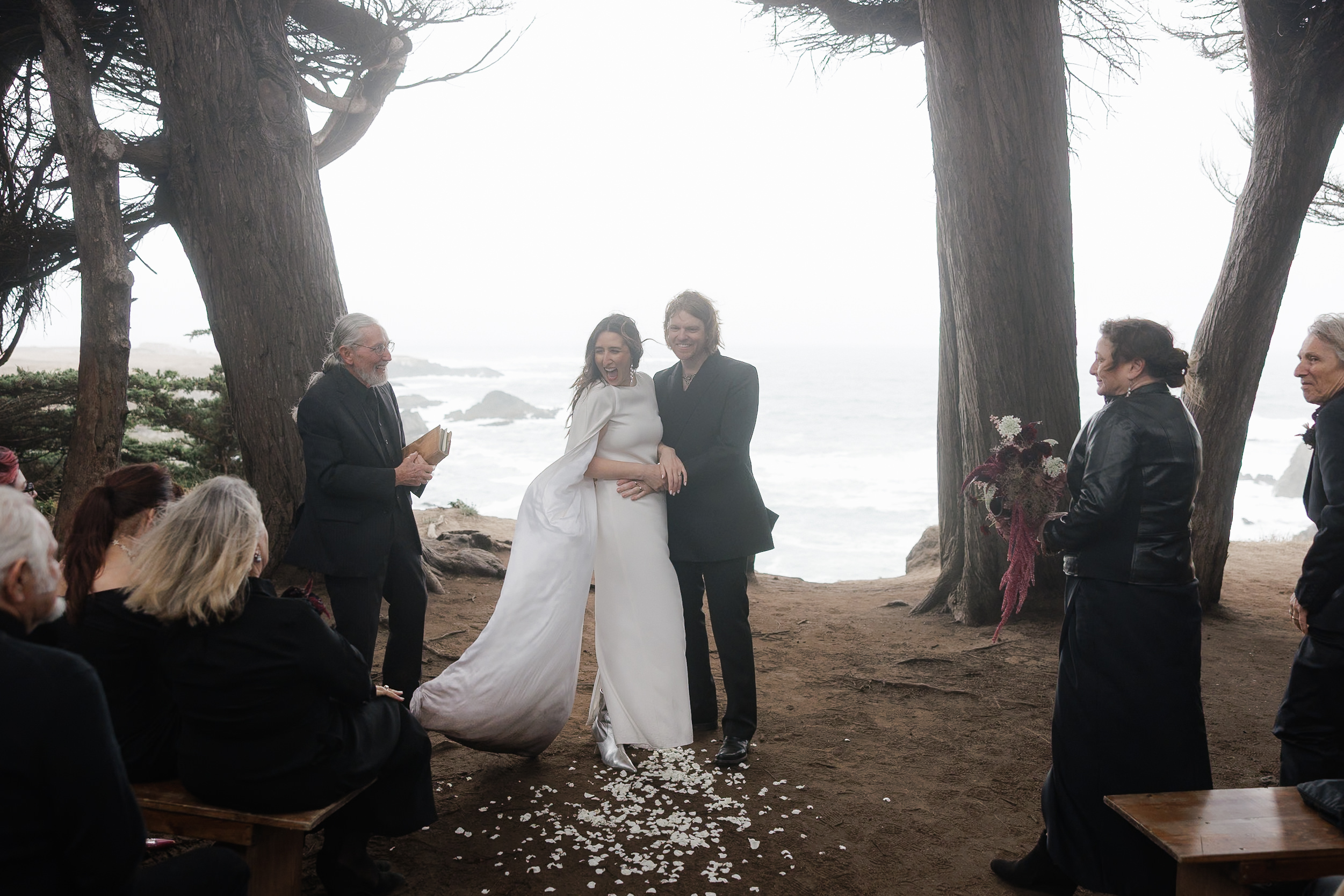 Elegant Outdoor Beach Wedding in Mendocino: Bride & Groom Amidst Majestic Trees and Ocean Views.