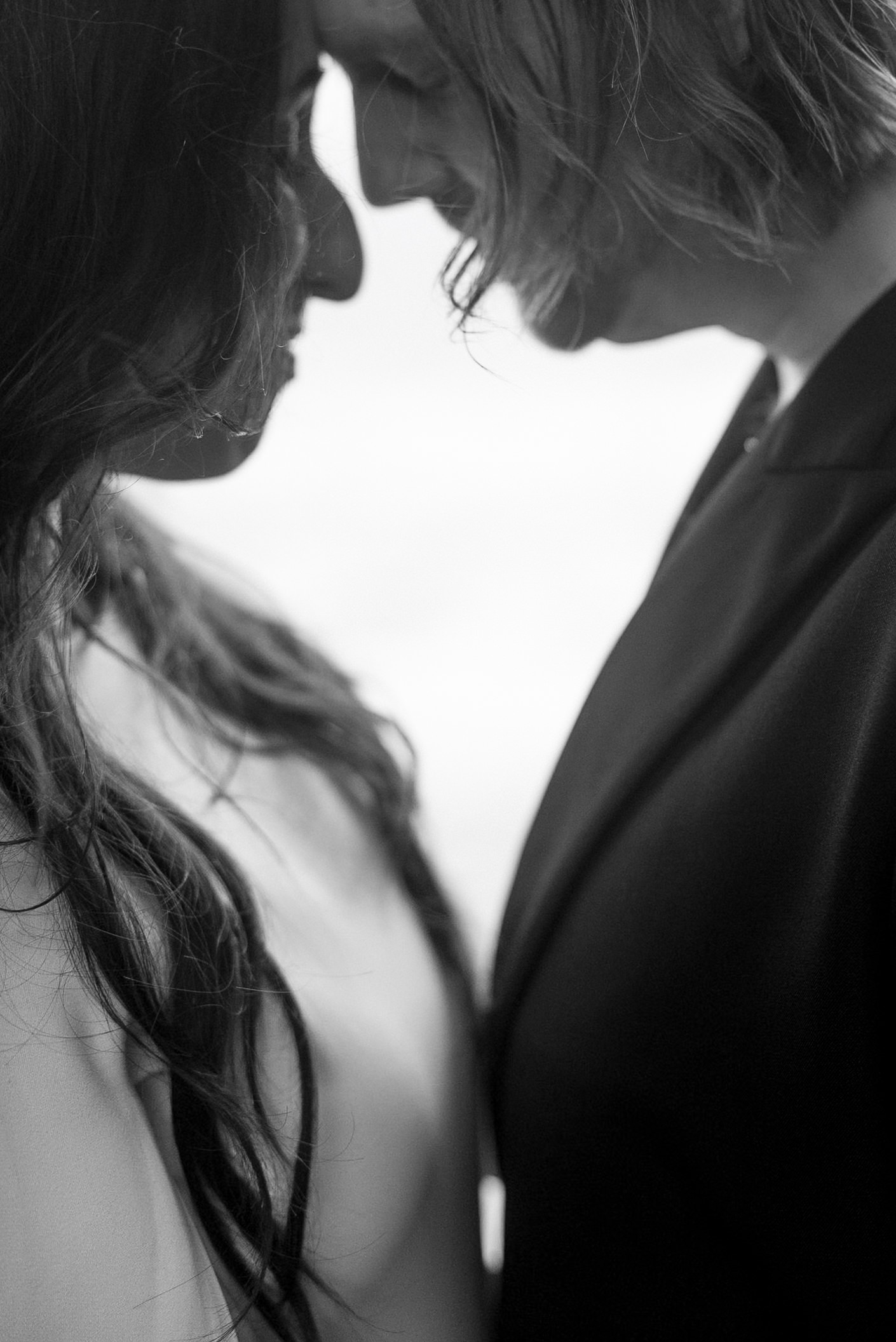 Black and white intimate moment; Mendocino couple embracing, serene connection, wedding photography.