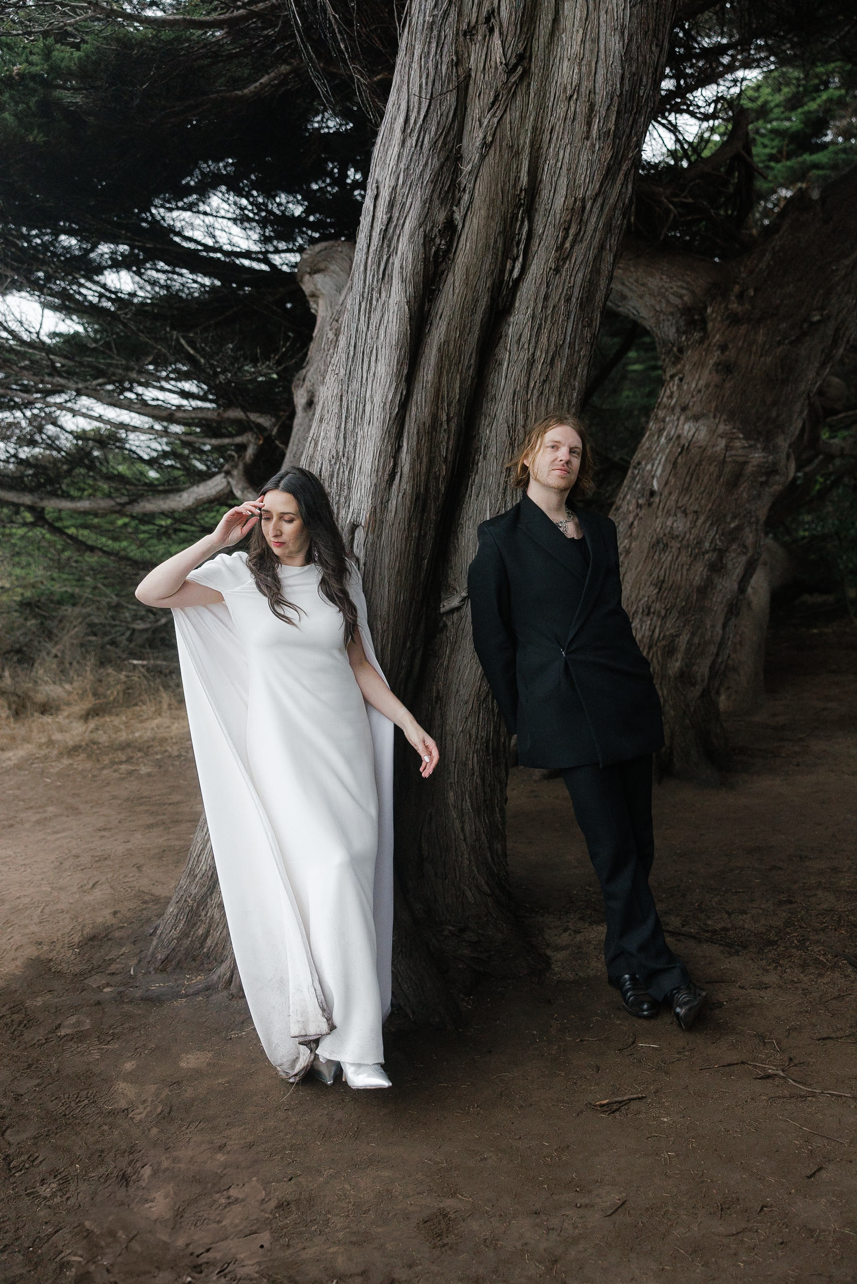 Elegant Mendocino Wedding: Bride and Groom Pose Among Enchanting Foliage by Twisting Tree.