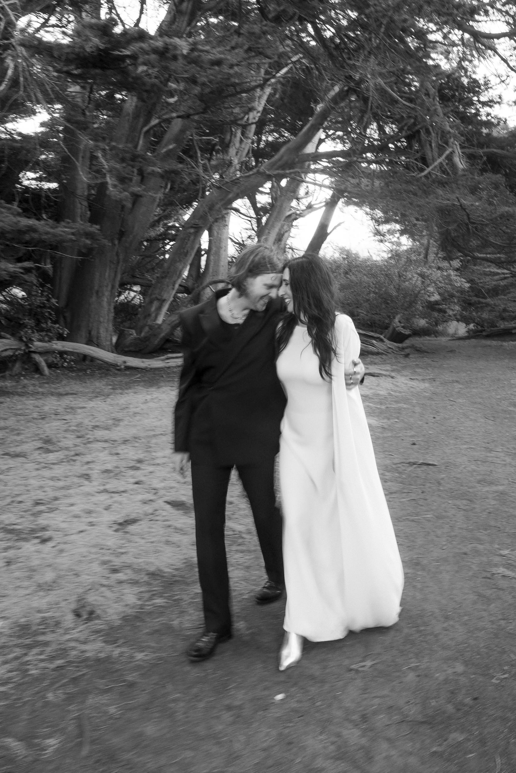 Dreamy Mendocino Wedding: Couple Embracing on Tree-Lined Path in Black-and-White Elegance.