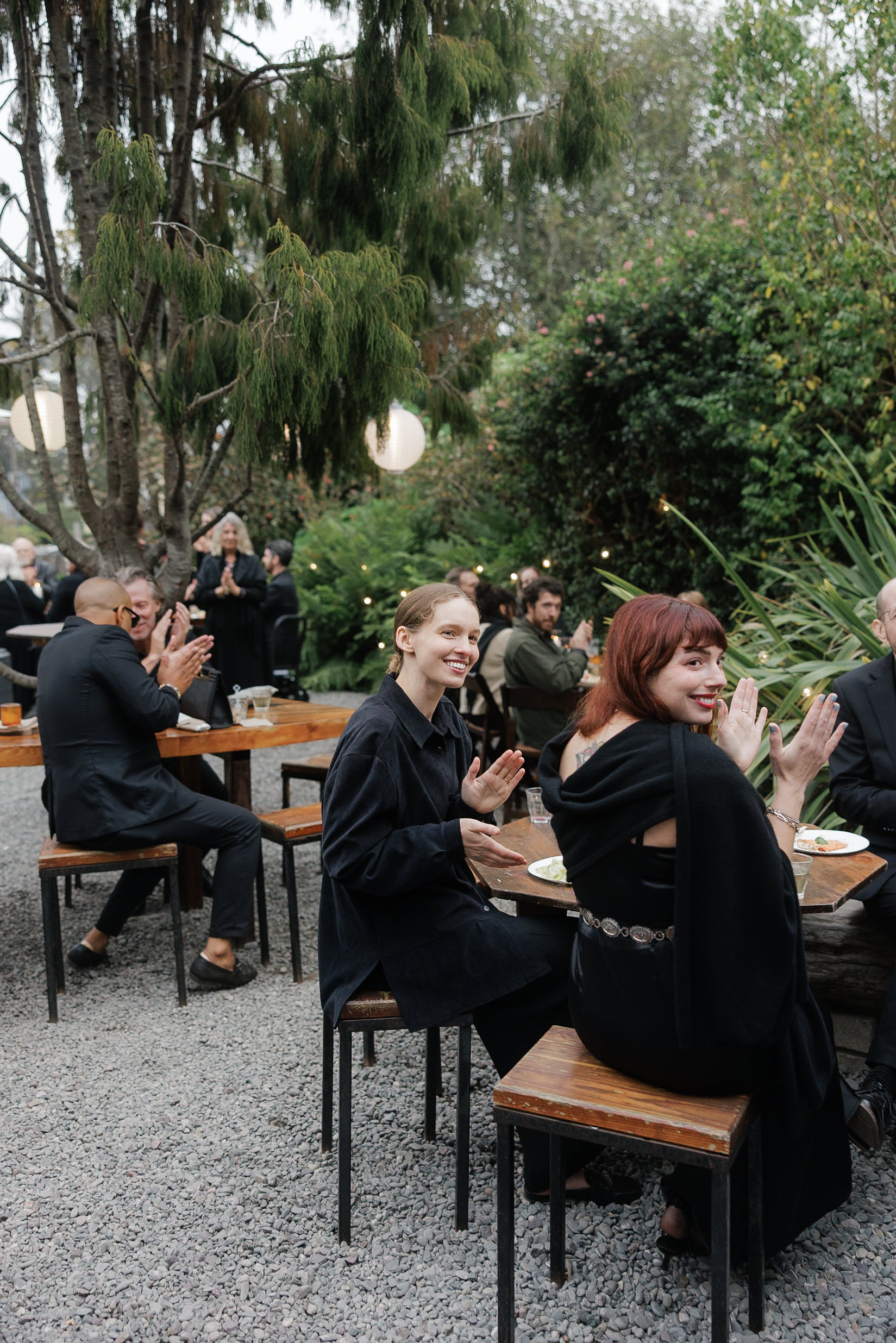 Elegant Outdoor Wedding in Mendocino: Guests Applauding Under Enchanting String Lights.