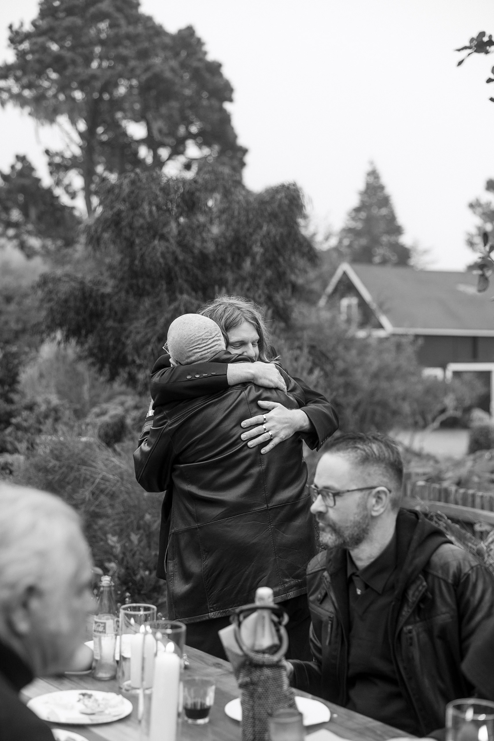 Elegant Black & White Mendocino Wedding: Intimate outdoor embrace under trees.