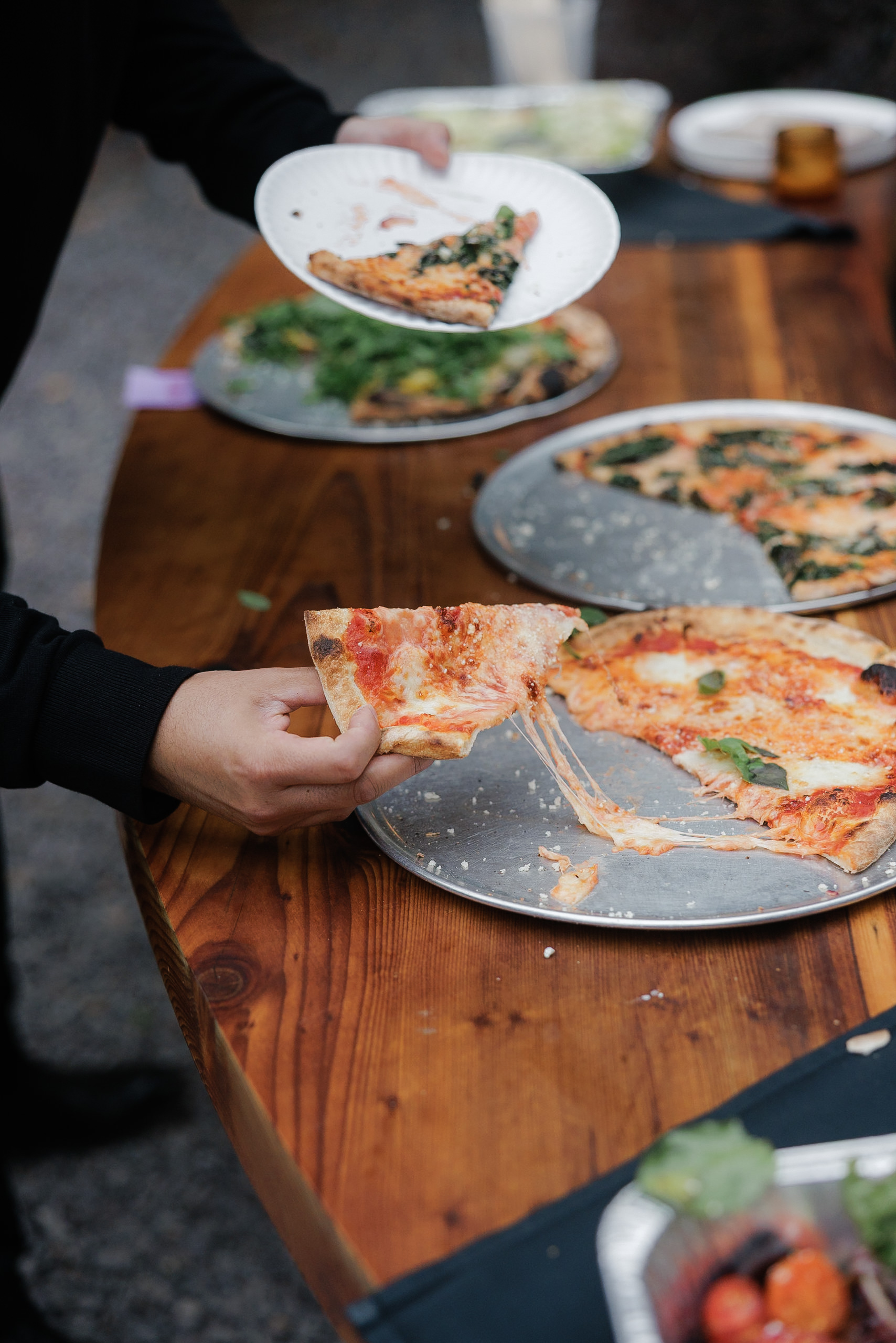High-end wedding photography: Rustic pizza feast in Mendocino, diverse toppings & charming details.
