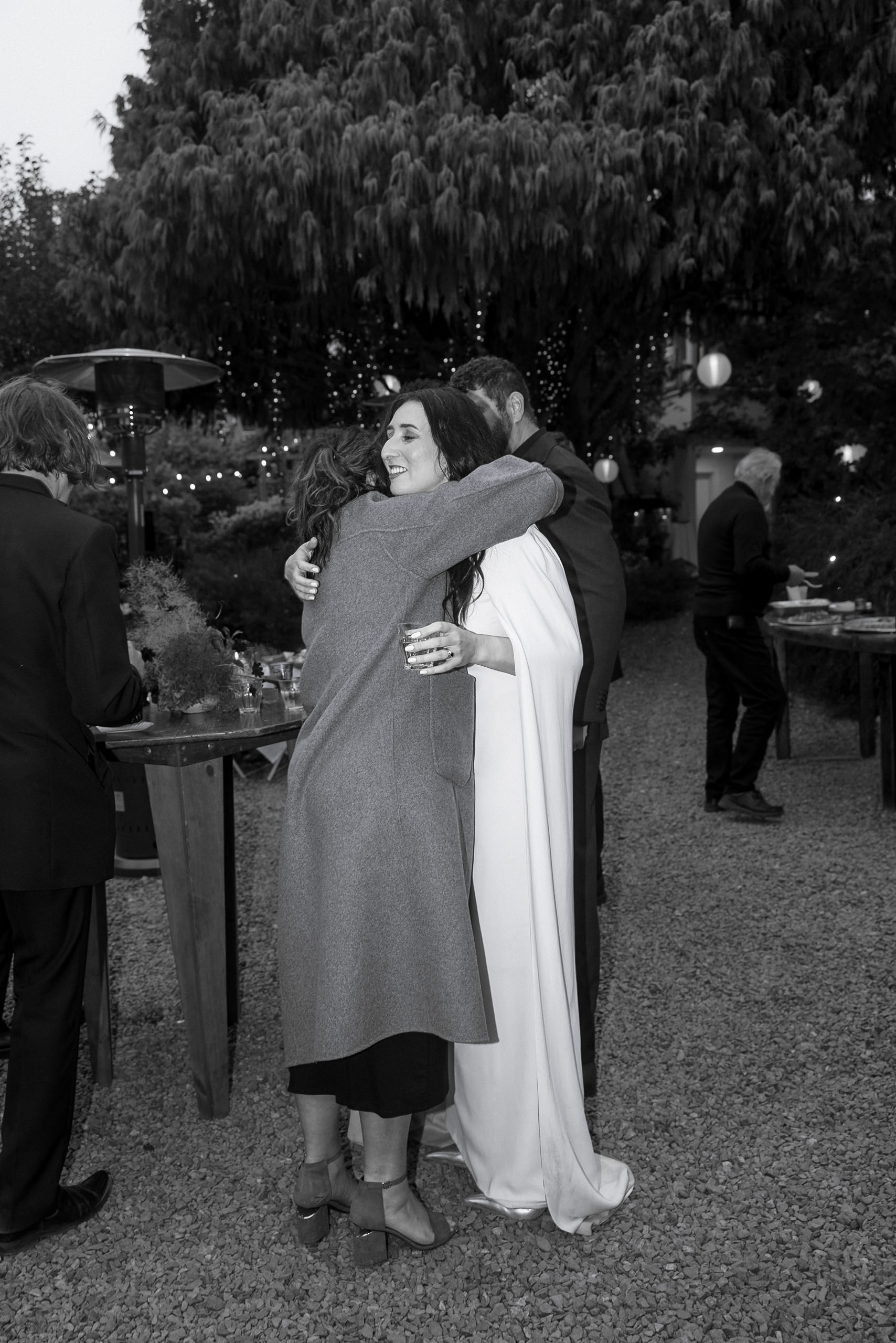 Elegant black-and-white photo of two women embracing at a rustic outdoor Mendocino wedding.