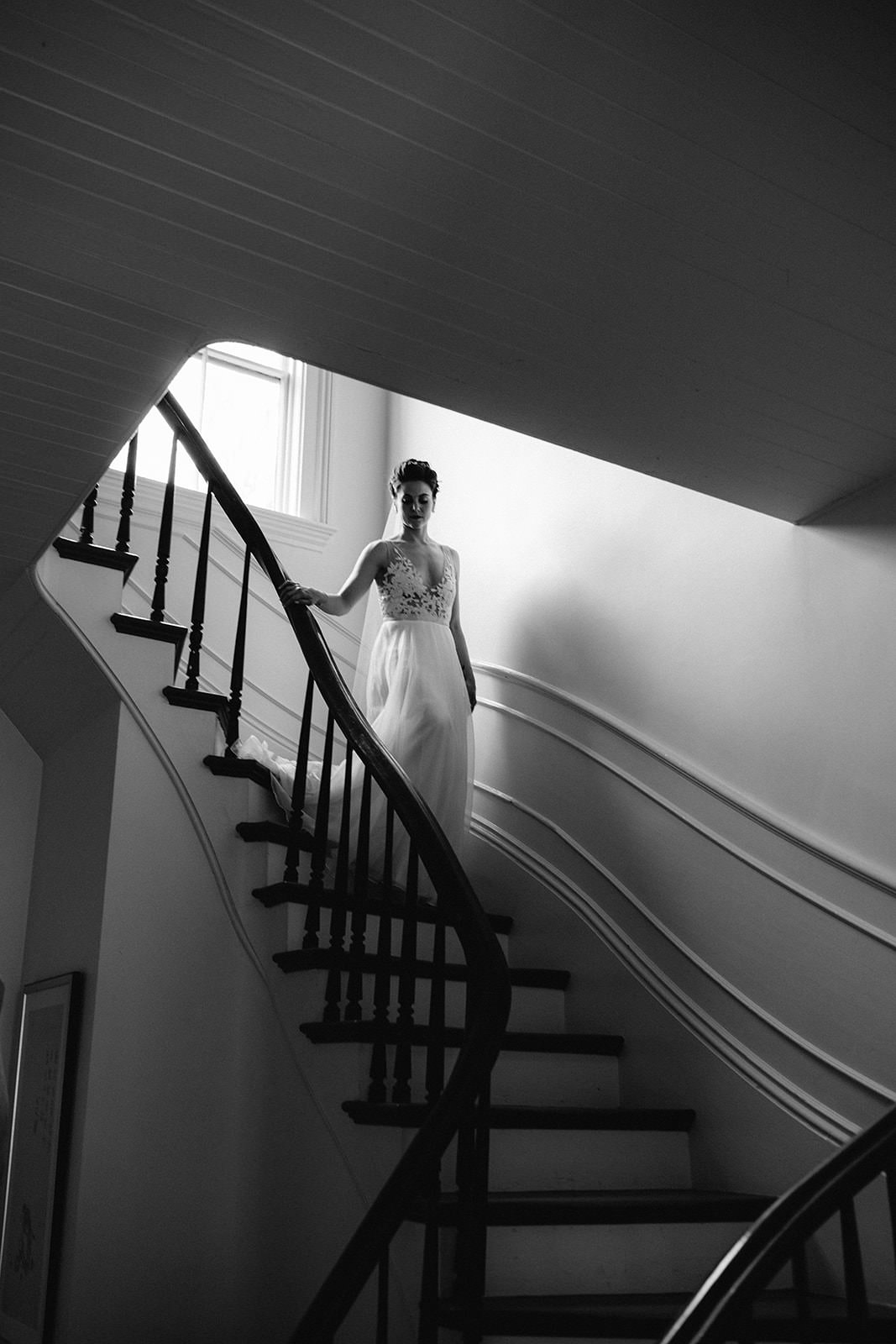 Elegant black-and-white wedding portrait on Cuffey Coves curved staircase, capturing timeless grace.