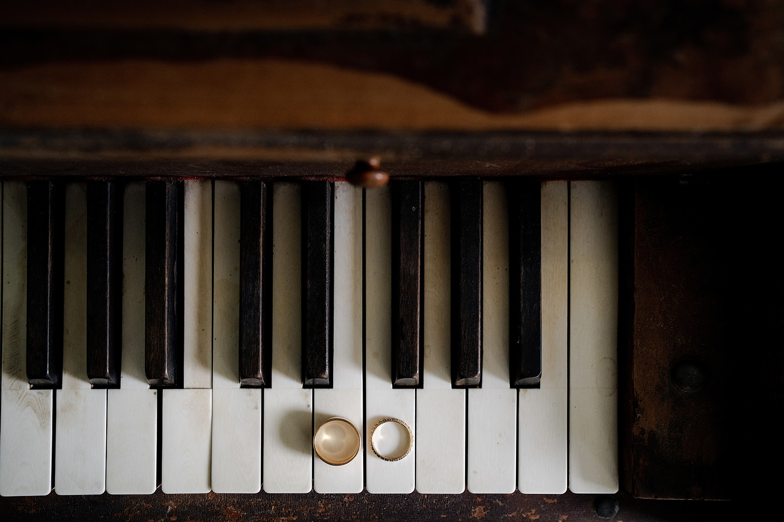 Elegant wedding rings on vintage piano keys at Cuffey Cove | Elk rustic charm.