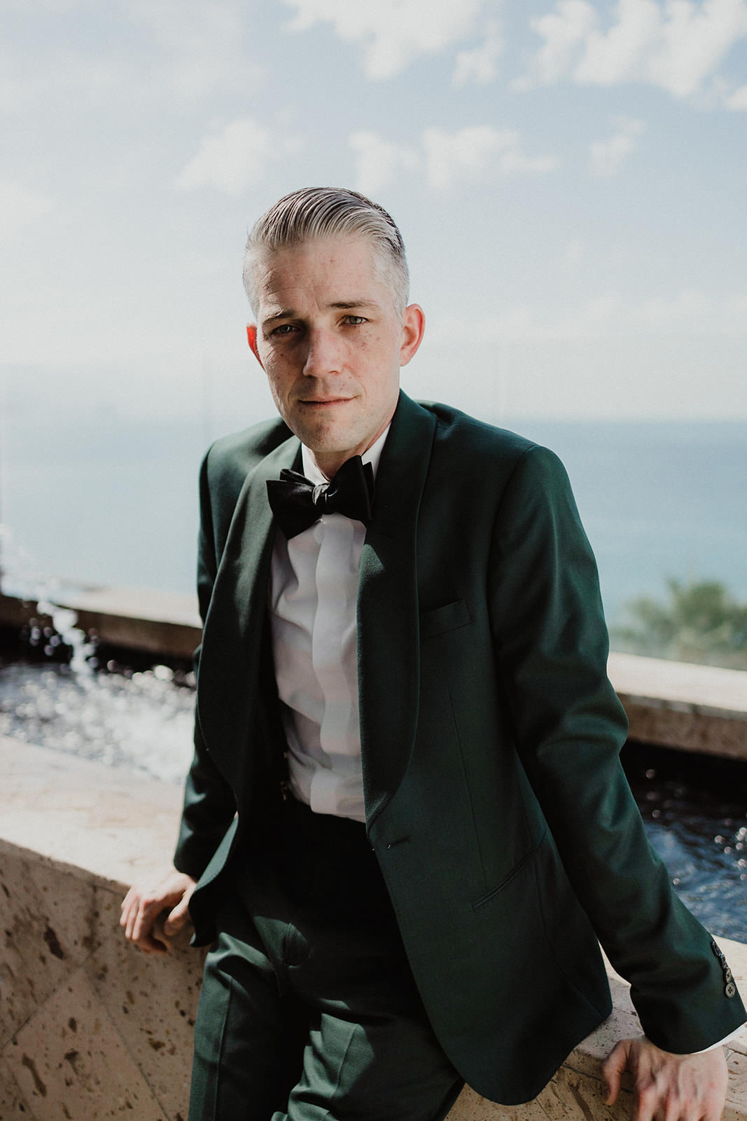 Elegant Destination Wedding Portrait: Dark Green Suit, Puerto Vallarta Bright Sky Background.