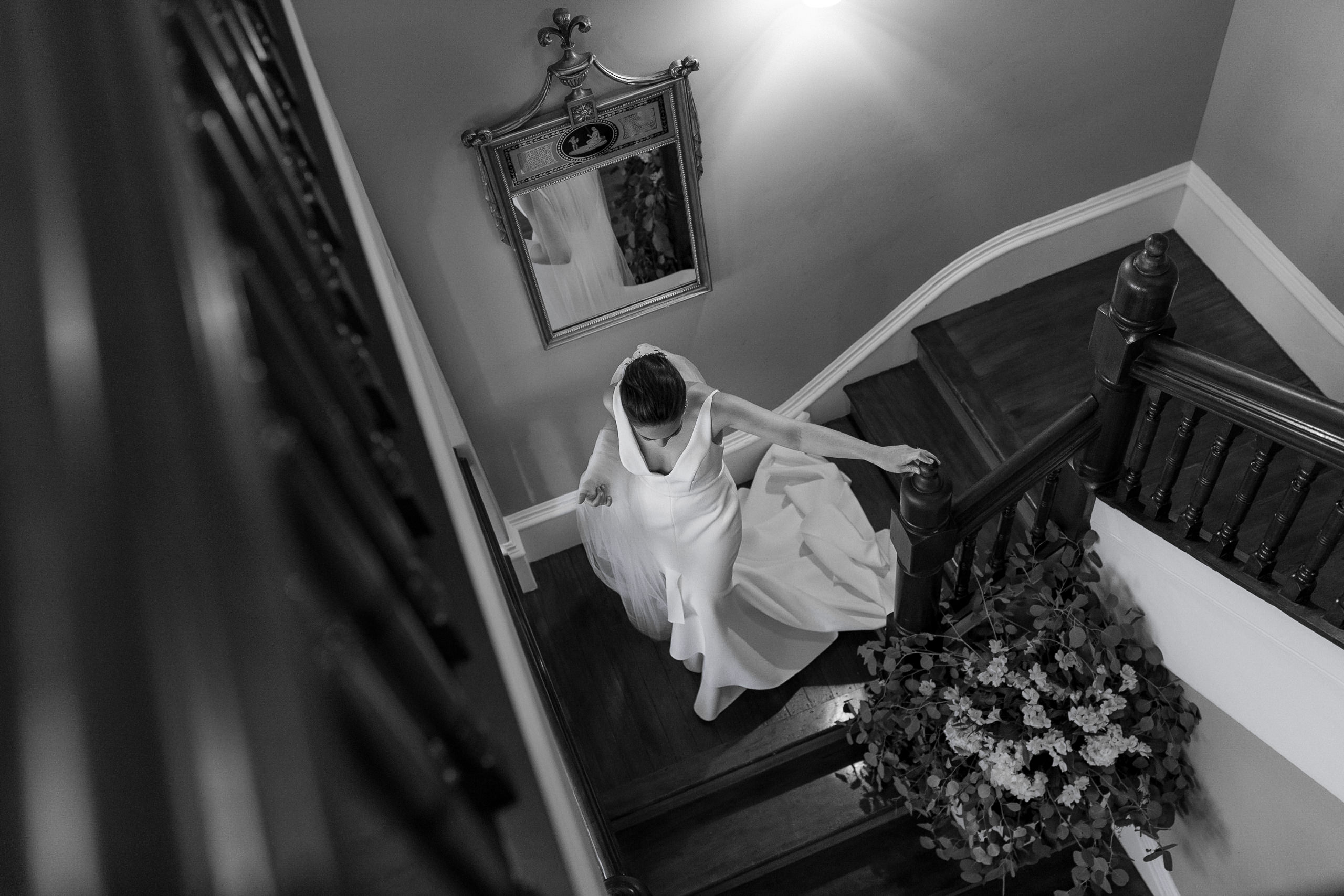 Elegant Bride in White Gown on Wooden Staircase - Classic Wedding Photography.