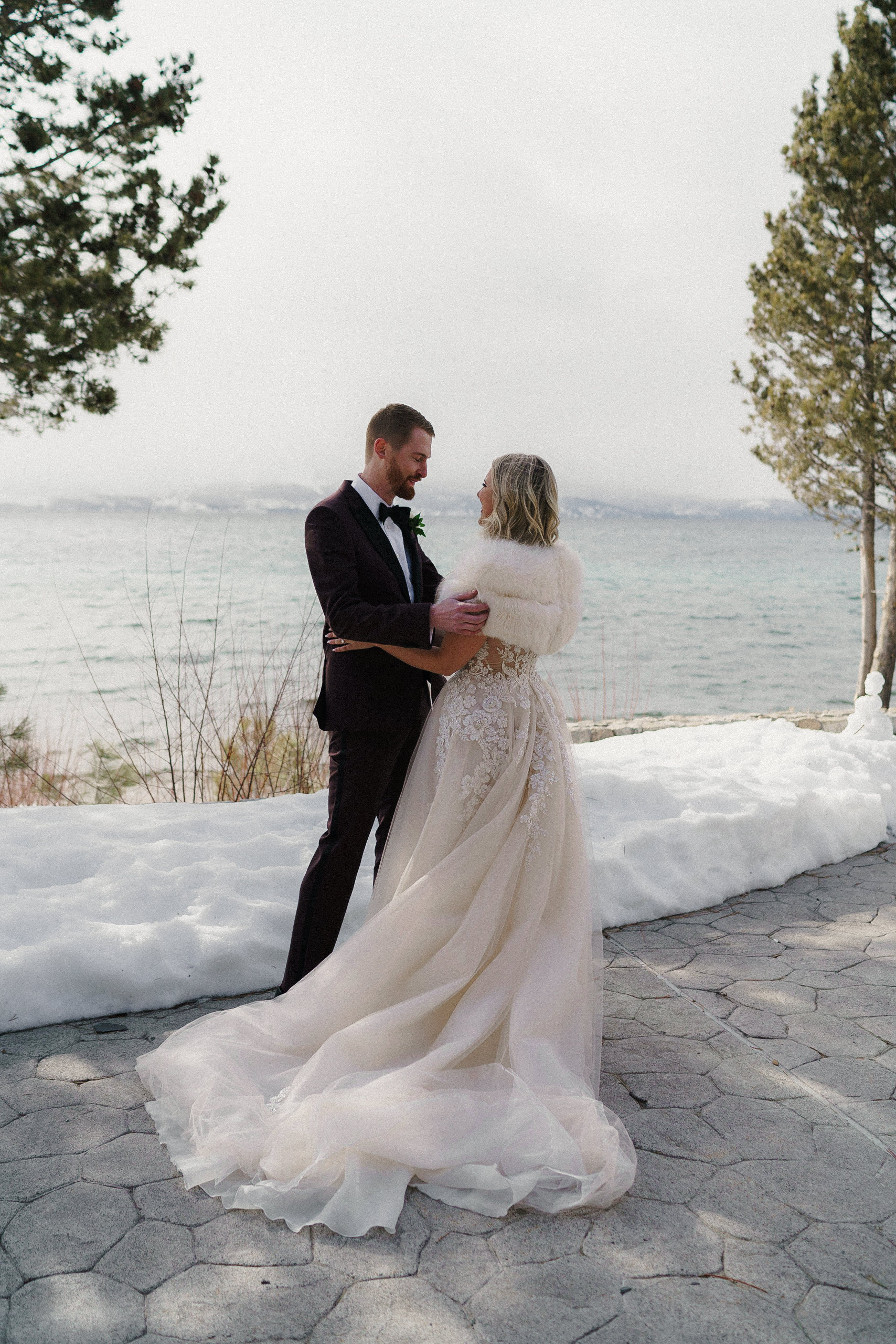 Elegant Lakeside Wedding Photography in Snowy Lake Tahoe: Bride & Groom Amidst Natures Beauty.