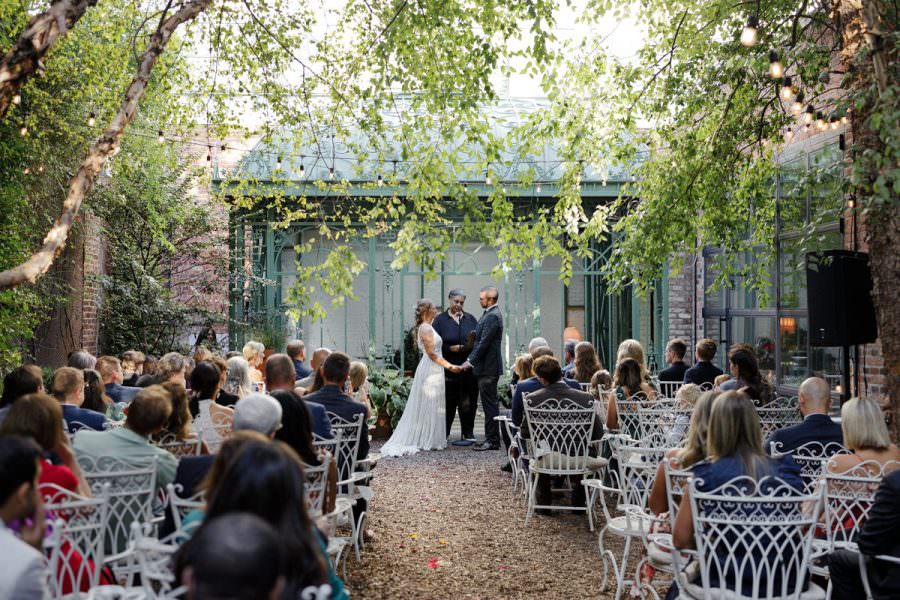 Elegant Outdoor Wedding Ceremony | Couple at the Altar | Lush Green Venue & String Lights.