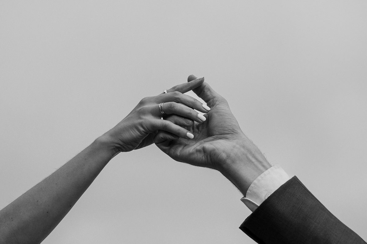 Elegant Black and White Close-Up: Hands Reaching, One with Ring. Premium Wedding Photography.