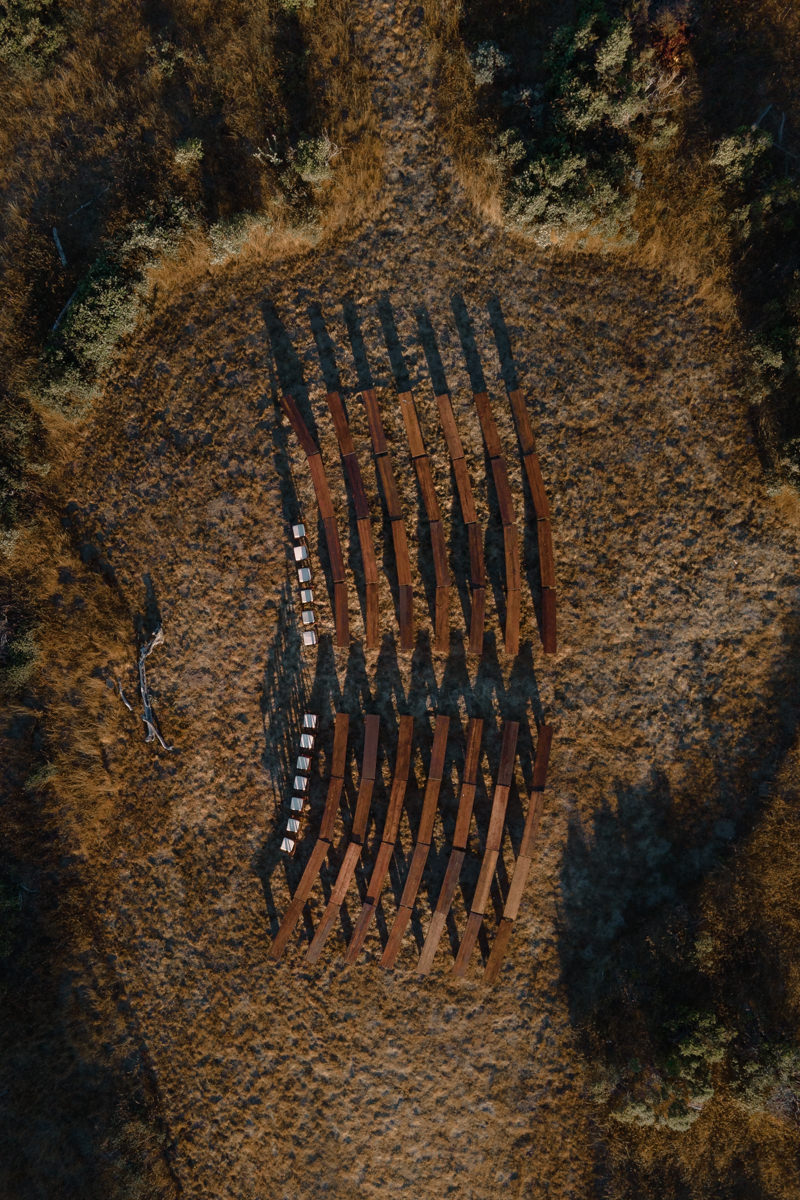Aerial photography of rustic beams on a dry field, perfect for wedding ambiance inspiration.