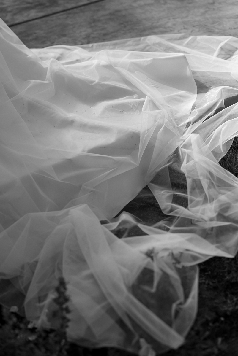 Elegant black and white photo of translucent fabric, showcasing texture and movement in soft folds.