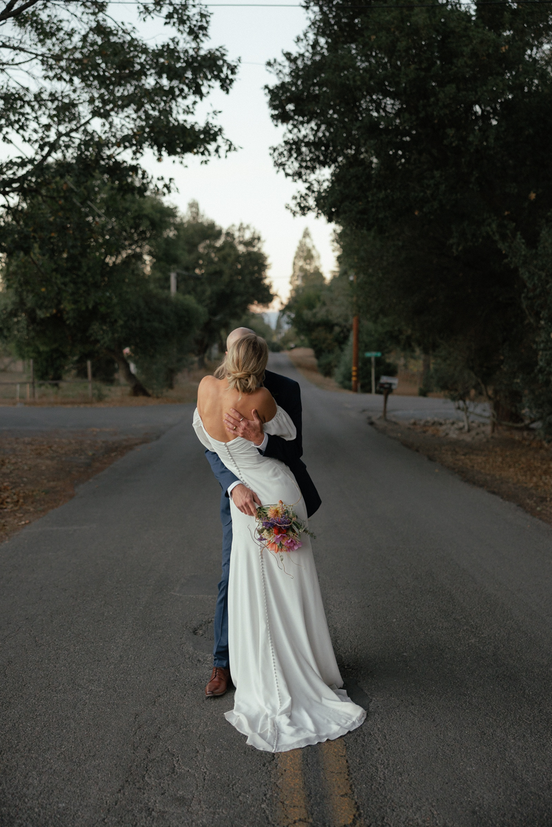 Elegant Countryside Wedding Photography: Passionate Embrace Amidst Rustic Charm.